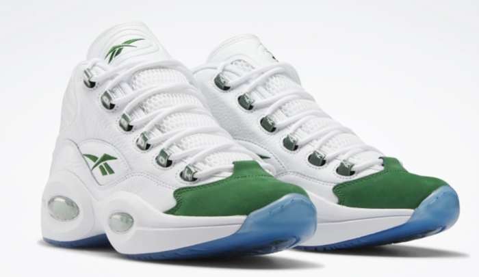 View ofwhite and green Reebok shoes.